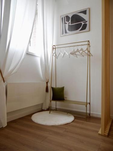 une pièce avec un tapis, une fenêtre et une chaise dans l'établissement Le Blum Studio *Hyper-Centre* avec *CANAL PLUS*, à Amiens