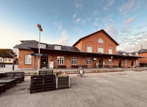 ティステズにあるThisted Banegårdのレンガ造りの大きな建物(ベンチ付)