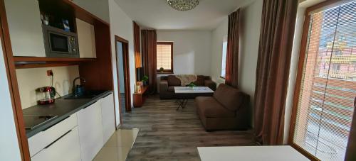 a kitchen and living room with a couch and a table at Apartment FIMM in Veľká Lomnica