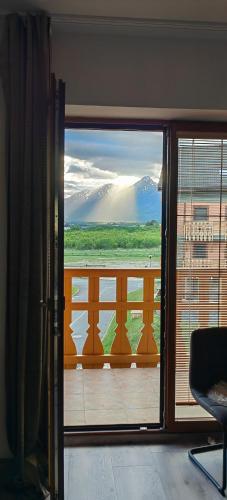 a door to a balcony with a view of a mountain at Apartment FIMM in Veľká Lomnica