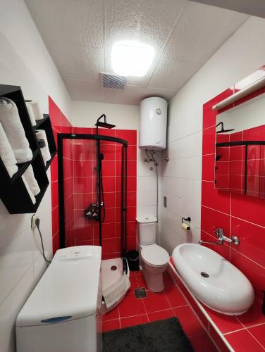 a red and white bathroom with a toilet and a sink at Heritage Apartments Trumbić in Split