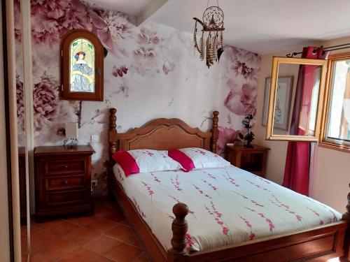 a bedroom with a bed with pink floral wallpaper at Domyv'Loup in Entrevaux