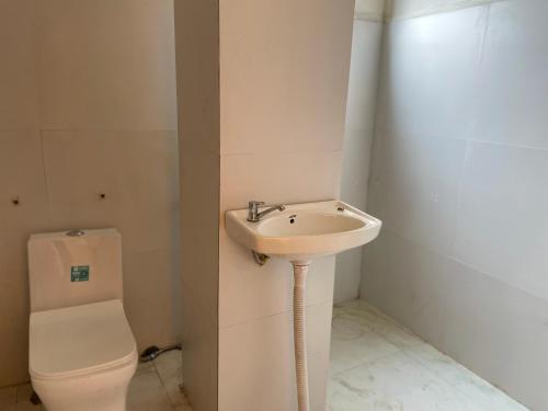 ein Bad mit einem Waschbecken und einem WC in der Unterkunft Stay at Paradise in Aizawl