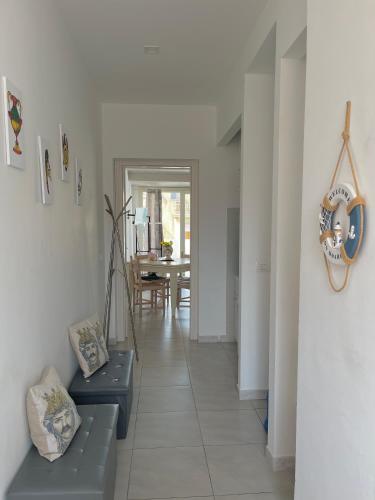 a hallway with two blue benches and a dining room at SFEA HOME in Pachino