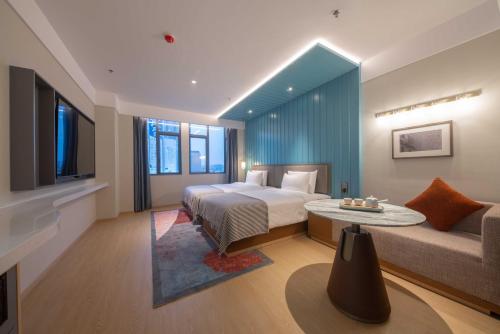 a hotel room with a bed and a couch at CityNote希诺酒店(广州北京路步行街新大新店) in Guangzhou