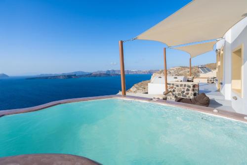 a swimming pool with a view of the ocean at Akron Terra Houses in Akrotiri