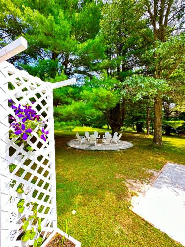 a white fence with white chairs and purple flowers at The best Vacation Home in Scotrun