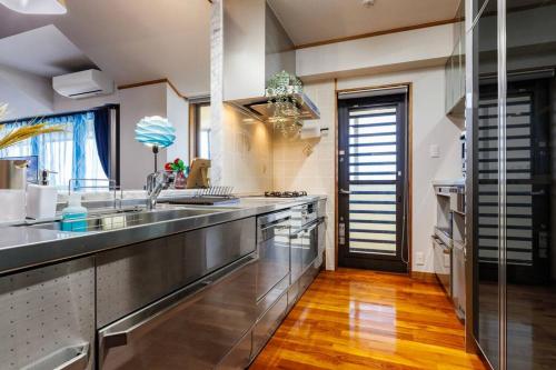 a large kitchen with a stainless steel counter top at 恩納村飲食店の中心地ビーチまで徒歩3分最大12名貸切コーディアルステイ in Fuzuchi