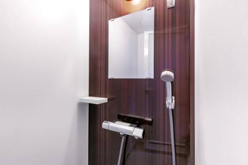 a bathroom with a shower with a mirror at 恩納村飲食店の中心地ビーチまで徒歩3分最大12名貸切コーディアルステイ in Fuzuchi