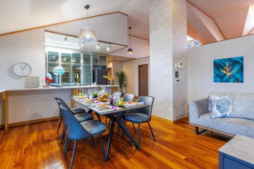 a dining room and living room with a table and chairs at 恩納村飲食店の中心地ビーチまで徒歩3分最大12名貸切コーディアルステイ in Fuzuchi