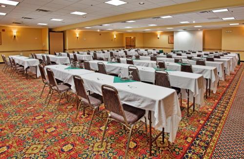 Holiday Inn Hotel & Suites Springfield, an IHG Hotel في سبرينغفيلد: غرفه كبيره فيها طاولات وكراسي
