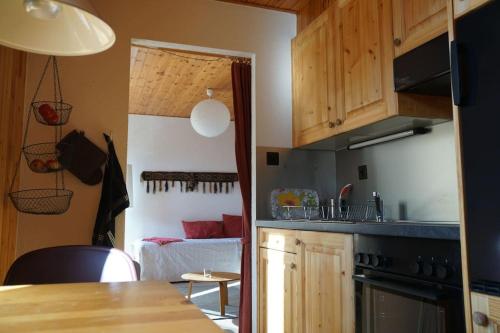 a kitchen with a counter top and a room with a bed at Gemütliches Studio im Zentrum in Evolène