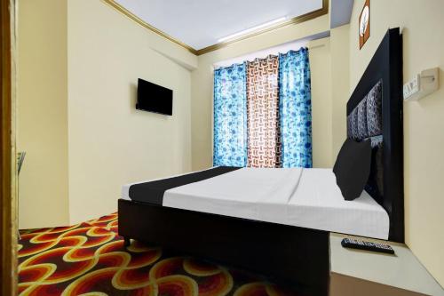 a bedroom with a bed and a television in it at OYO Hotel Basera in Shimla
