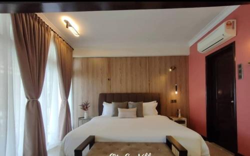 sypialnia z dużym białym łóżkiem i oknem w obiekcie The Green Lagoon w mieście Pantai Cenang