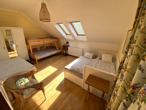 a attic room with two beds and a table at Na Husovce in Teplice