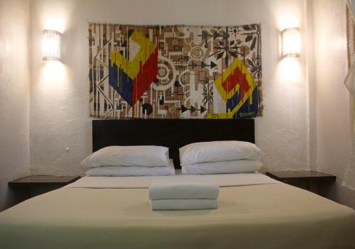 a bedroom with a large bed with two pillows at Lazy Dog Bed & Breakfast in Boracay