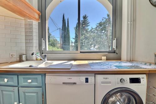uma cozinha com uma máquina de lavar roupa e uma janela em Domaine du Peymian-Villa Art Deco em La Ciotat
