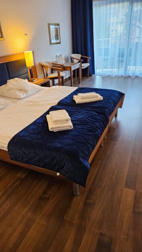 a hotel room with a bed with two towels on it at Bursztyn Resort in Kołobrzeg