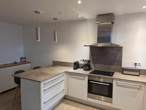 une cuisine avec des armoires blanches et un four à plaques de cuisson dans l'établissement Appartement proche de Porto-Vecchio, à Porto-Vecchio