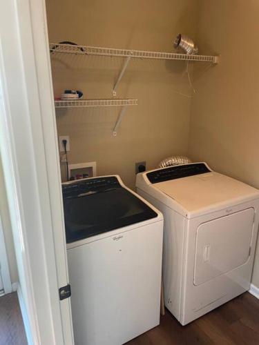 uma lavandaria com uma máquina de lavar roupa e uma máquina de lavar roupa em 3 bedroom 2 bathroom House em Columbia