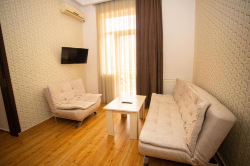 salon z kanapą, krzesłem i stołem w obiekcie IRISE w mieście Batumi