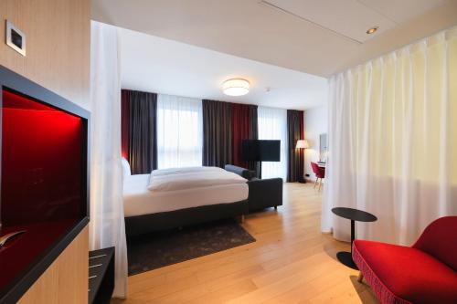 a hotel room with a bed and a flat screen tv at IntercityHotel Lübeck in Lübeck