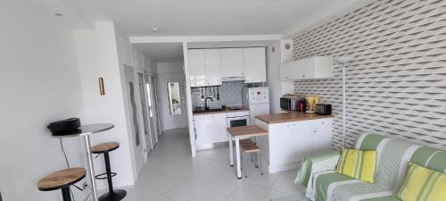 une cuisine avec des armoires blanches et une table et des chaises dans l'établissement Studio plage de sable, à Antibes