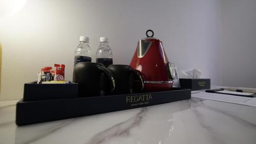 a tray with a tea kettle and two bottles of water at Best Stay at Kozi Square in Kuching