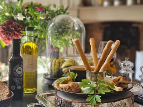 a table with a plate of food and a bottle of wine at La Divine Com&eacute;die-Suites Deluxe in Avignon