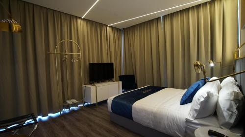 a hotel room with a bed and a television at Best Stay at Kozi Square in Kuching