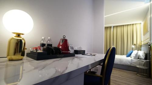 una camera con un tavolo con una lampada e un letto di Best Stay at Kozi Square a Kuching