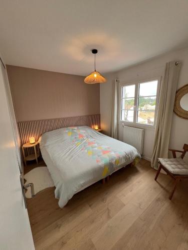 une chambre avec un grand lit et une fenêtre dans l'établissement Maison 8/10 pers / piscine chauffée / St Palais sur Mer, à Saint-Palais-sur-Mer