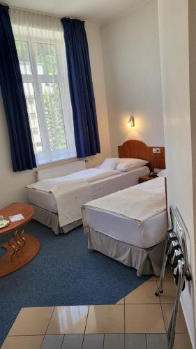 a hotel room with two beds and a window at Hotel Margit in Trenčianske Teplice