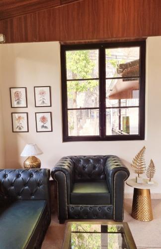 a living room with a leather couch and a window at Marten's Wilderness Retreat in Lansdowne