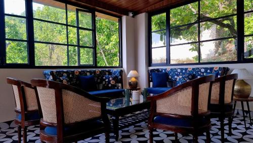 a living room with chairs and a table and windows at Marten's Wilderness Retreat in Lansdowne