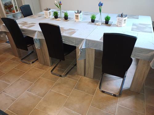 a dining room table with chairs and potted plants at Penzion Romance in Vyšší Brod