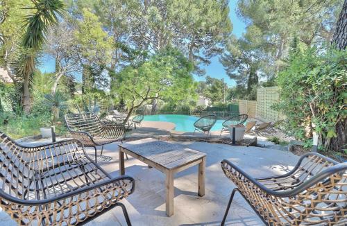 une terrasse avec des chaises, une table et une piscine dans l'établissement Domaine du Peymian-Villa Art Deco, à La Ciotat