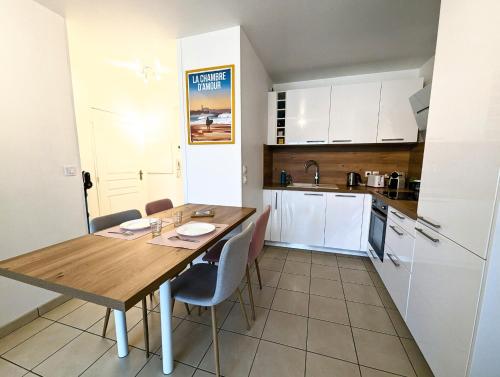 - une cuisine avec une table et des chaises en bois dans la chambre dans l'établissement Le Paisible YourHostHelper, à Bayonne