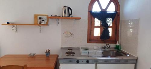 cocina con fregadero y ventana en fi naxos, en Agios Prokopios