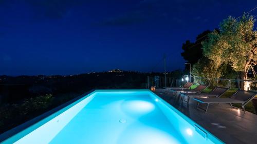 a blue swimming pool at night with lights at DIMORA CAMPO DELLE MURA 4&2, Emma Villas in Acquaviva Picena