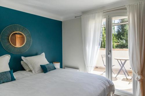 une chambre avec un lit avec un mur bleu dans l'établissement Villa Sena Eyragues, familiale, à Eyragues