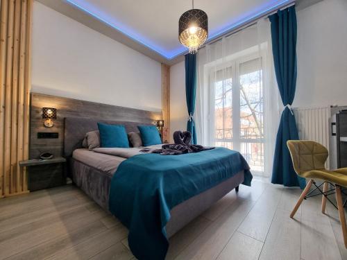 1 dormitorio con cama con sábanas azules y ventana en DunaCentroom, en Dunaújváros