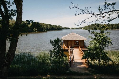 une petite cabine sur un quai au bord d'un lac dans l'établissement Folwark Łękuk, à Łękuk Mały