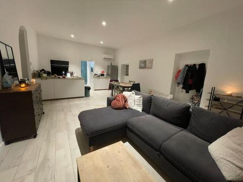 un salon avec un canapé noir et une table dans l'établissement Quartier San Damianu - Sartène, à Sartène