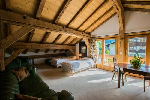 a bedroom with a bed and a couch and a table at La Ferme du Château in La Chapelle-dʼAbondance