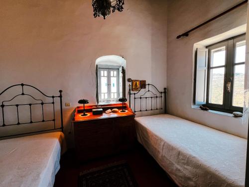 a bedroom with two beds and a mirror at Stunning town-house in Chora, Serifos in Serifos Chora