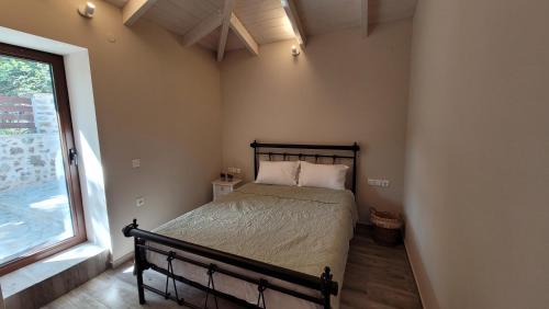 a bedroom with a bed and a window at The Stone House in Parga