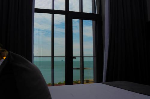 a bedroom with a window looking out at the ocean at Port Marine Hotel By HOLLYWOOD in Baku