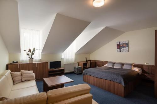 een grote slaapkamer met een bed en een bank bij Horský hotel Remata in Ráztočno