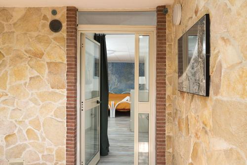 a room with a stone wall with a door and a bedroom at Casa Spisone in Taormina